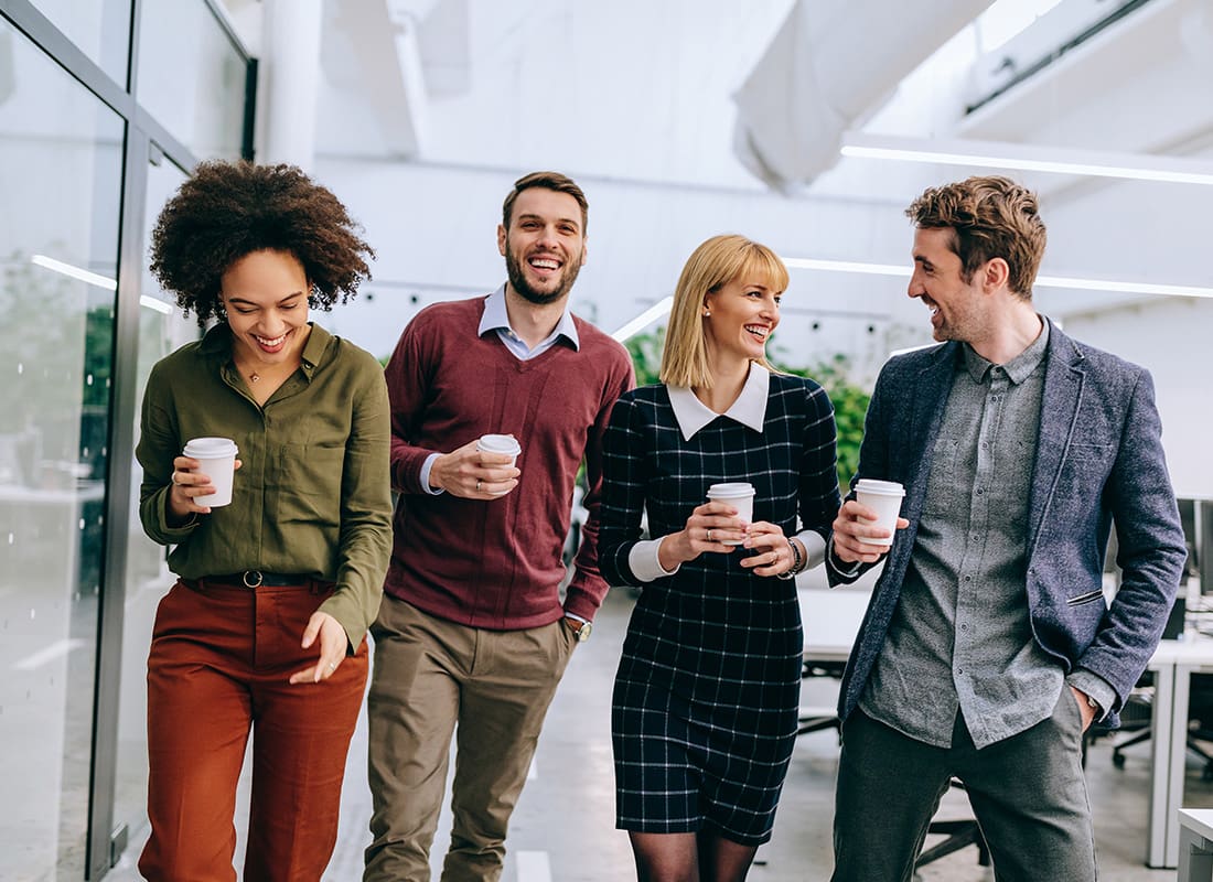 Insurance Solutions - Group of Friendly Business Professionals Walking Together in an Office